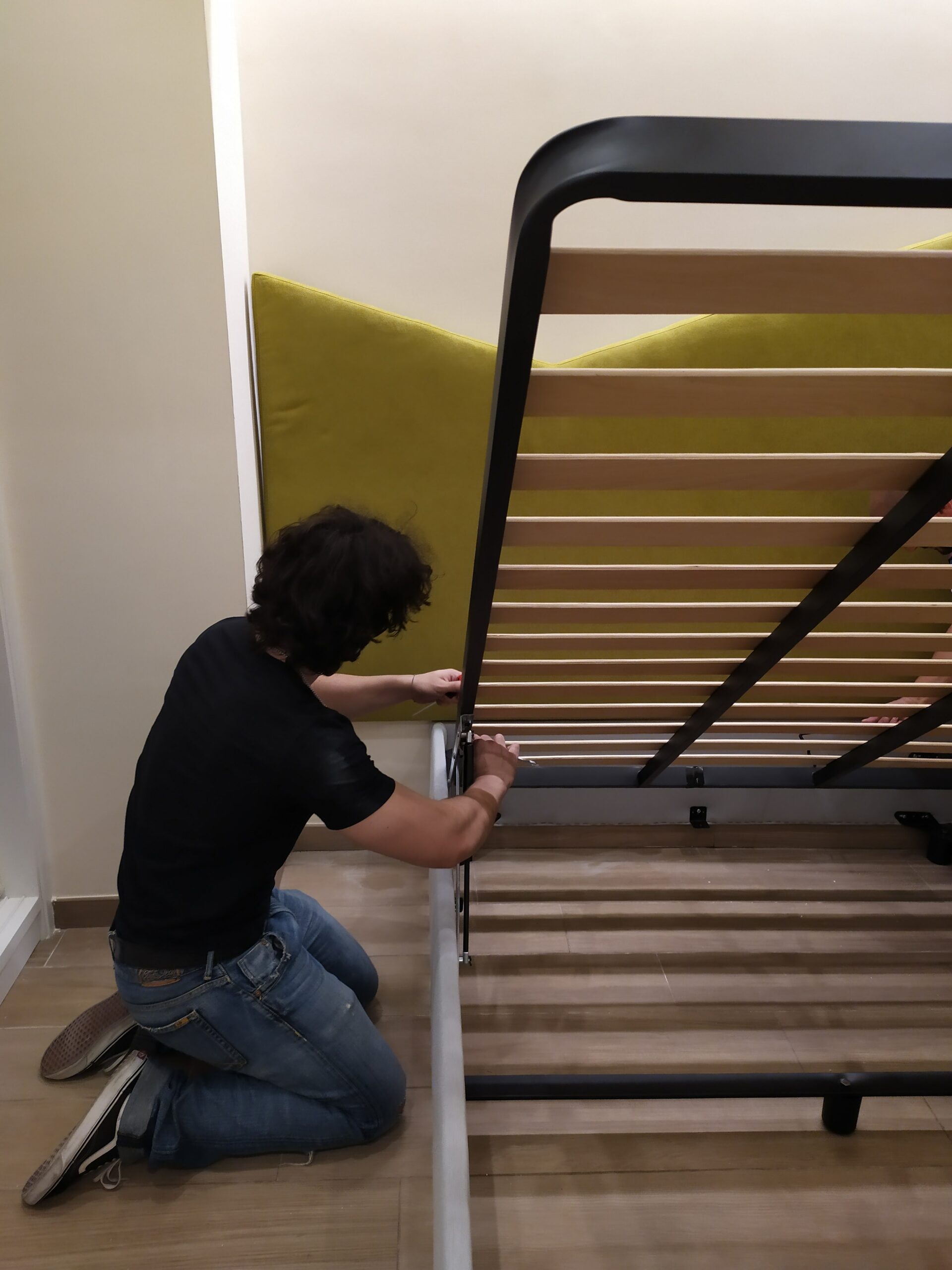 Montatore che installa un letto contenitore imbottito a casa della cliente